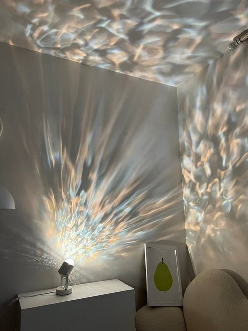 MAVI lampe de table projecteur d'ambiance avec des ondulations lumineuses dynamiques projetées sur les murs et le plafond.
